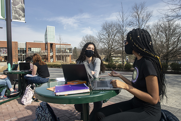 Students outside on the Fairfax Campus March 2021 Students sit outside at a table at the Fairfax Campus