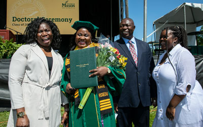 Graduating doctoral student with family Graduating doctoral student with her family on Mason's Fairfax Campus